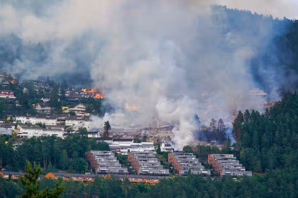 Firefighters battle to control the blaze in Krokstadelva as it spreads to a nearby forest