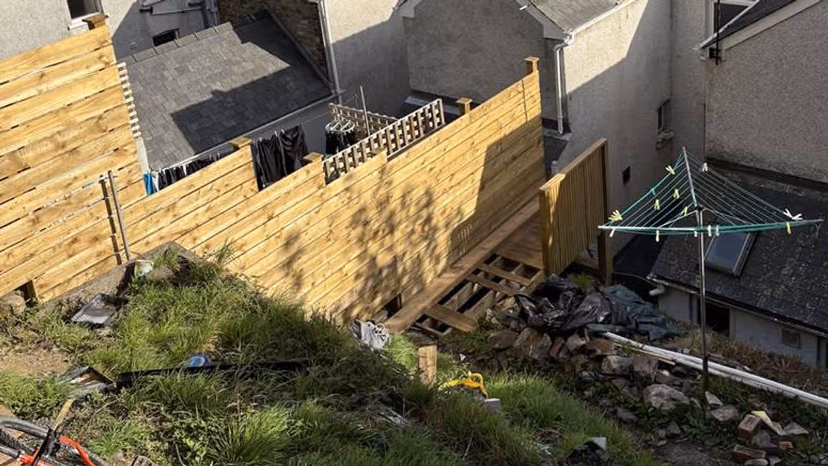 Homeowner ordered to tear down massive fence and garden staircase.