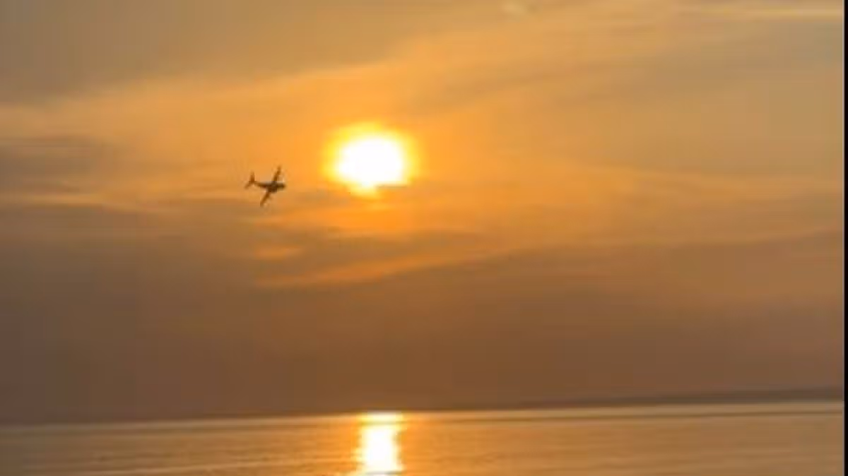 Stunning moment plane flies over Welsh beach at sunset