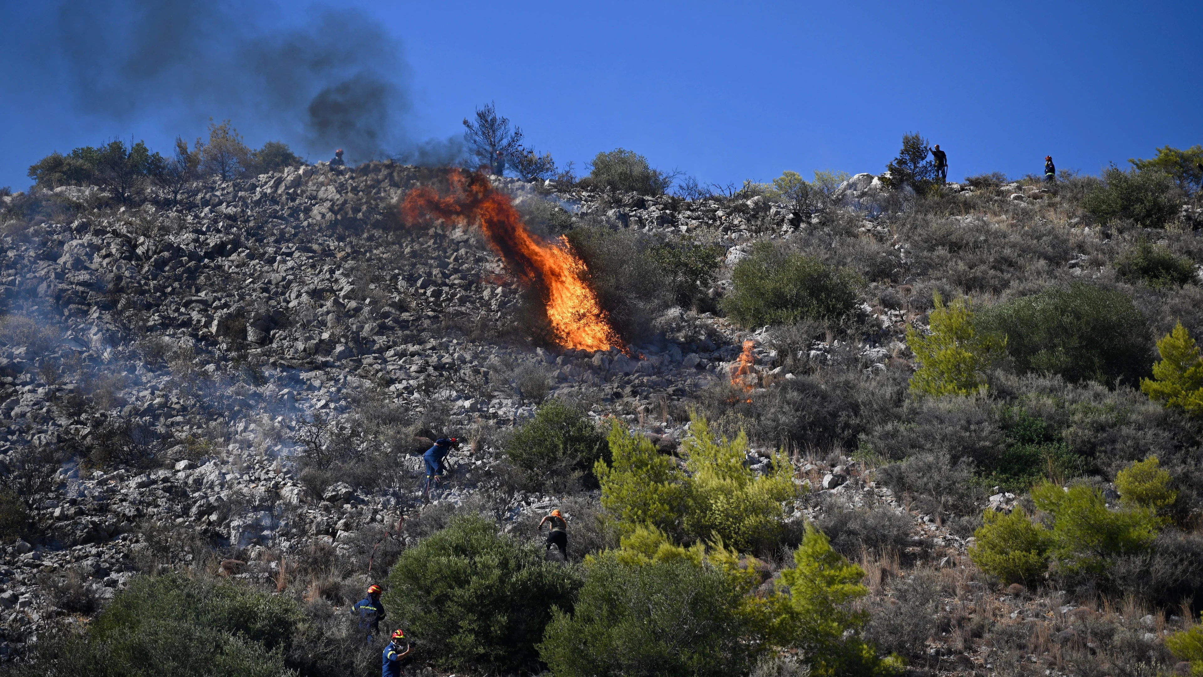 Fire crews battle blazes in Belgium and Greece as two die on island near Athens