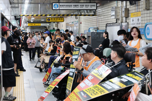 Activists staged a boarding protest at Hyehwa Station, causing trains to skip stops for about an hour on Monday morning